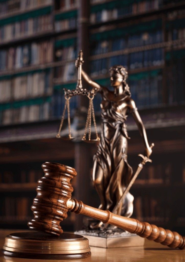 Bronze statue of Lady Justice behind a wooden gavel
